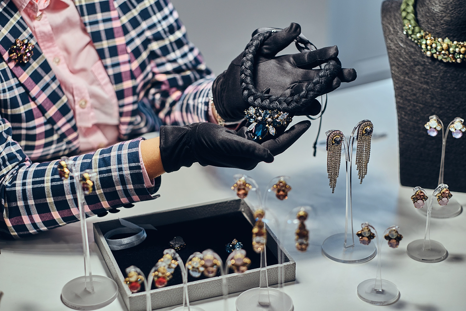 close-up-photo-jewelry-worker-presenting-costly-necklace-with-gemstones-luxury-jewelry-store copy